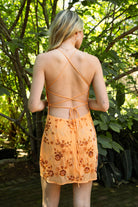 Woman wearing TIC TOC DL31853 VEDA chiffon sequin beaded lace-up mini dress featuring intricate floral bead and sequin embroidery, a flattering V-neckline with slim halter strap, open back design with adjustable lace-up tie, and a body-skimming mini silhouette for a radiant festival and summer night-out look.