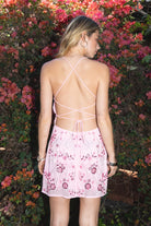 Woman wearing TIC TOC DL31853 VEDA chiffon sequin beaded lace-up mini dress featuring intricate floral bead and sequin embroidery, a flattering V-neckline with slim halter strap, open back design with adjustable lace-up tie, and a body-skimming mini silhouette for a radiant festival and summer night-out look.