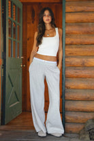 Woman wearing gray TIC TOC CASSE Fleece Sweatpants with built-in gingham boxer, front view with a matching rib tank top in a cabin. 