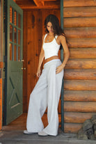 Woman wearing gray TIC TOC CASSE Fleece Sweatpants with built-in gingham boxer, side view with a matching rib tank top in a cabin. 
