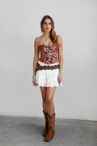 Model wearing red LOENA tapestry corset top with lace-up detailing, styled for a Coachella-inspired Western festival look