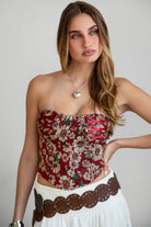Model wearing red LOENA tapestry corset top with lace-up detailing, styled for a Coachella-inspired Western festival look