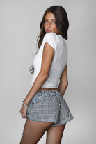 PC31149 BUNBUN &nbsp;Gingham Elasticated Shorts are the perfect blend of cozy and cute. Designed in a classic boxer fit with a low-rise stretch waistband and faux button detail, these lightweight gingham shorts are ideal for lounging or styling up for a casual day out. Pair with a baby tee, oversized sweatshirt, or matching gingham cami for that effortless "off-duty" look that's trending this season.