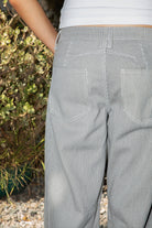 Woman wearing STETSON classic mid rise stripe wide leg denim pants featuring structured cotton stripe denim, classic mid rise waist, button and zip fly closure, subtle vertical stripe pattern, relaxed wide leg silhouette, full length fit, classic five pocket design, and belt loops for everyday western styling.
