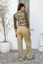 Woman wearing BOWDEN washed low rise wide leg denim pants featuring 100% cotton denim, relaxed vintage inspired silhouette, low rise waist, loose wide leg design, soft lived in washed finish, clean front styling, front zipper fly closure, classic back patch pockets, and full length fit.