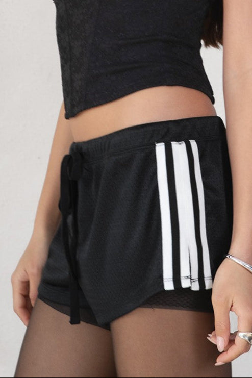 GINAH Solid Low-Rise Sport Shorts 
Elasticated Waistband With Connected Lace Tie 
White Side Straps 
Black Double Lined Nylon Fabric 