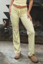 Woman wearing TIC TOC PH31905BA-NYLEE-WL navy NYLEE WL wide leg pants made from soft span jersey fabric, featuring a high-stretch body-hugging fit through the hips, foldover waistband with tie detail, and full-length wide leg silhouette, styled indoors with a matching top for a coordinated lounge/athleisure look.