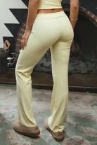 Woman wearing TIC TOC PH31905BA-NYLEE-WL navy NYLEE WL wide leg pants made from soft span jersey fabric, featuring a high-stretch body-hugging fit through the hips, foldover waistband with tie detail, and full-length wide leg silhouette, styled indoors with a matching top for a coordinated lounge/athleisure look.