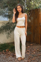 Woman wearing TIC TOC PH31982-LYNN-P LYNN high waist floral print pointelle pants featuring a high waisted elastic waistband with exposed lace trim, ribbed floral pointelle fabric, relaxed straight leg silhouette, and soft airy stretch jersey feel, styled with a fitted basic top for a feminine lounge and everyday look.