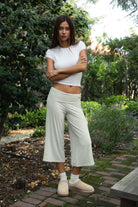 Woman wearing TIC TOC PH32000 SORA rayon spandex fold over low rise wide leg leggings featuring a soft lightweight jersey fabric, fold-over waistband, relaxed wide leg silhouette, and capri length, styled for a clean laid-back lounge and everyday look.