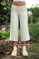 Woman wearing TIC TOC PH32000 SORA rayon spandex fold over low rise wide leg leggings featuring a soft lightweight jersey fabric, fold-over waistband, relaxed wide leg silhouette, and capri length, styled for a clean laid-back lounge and everyday look.