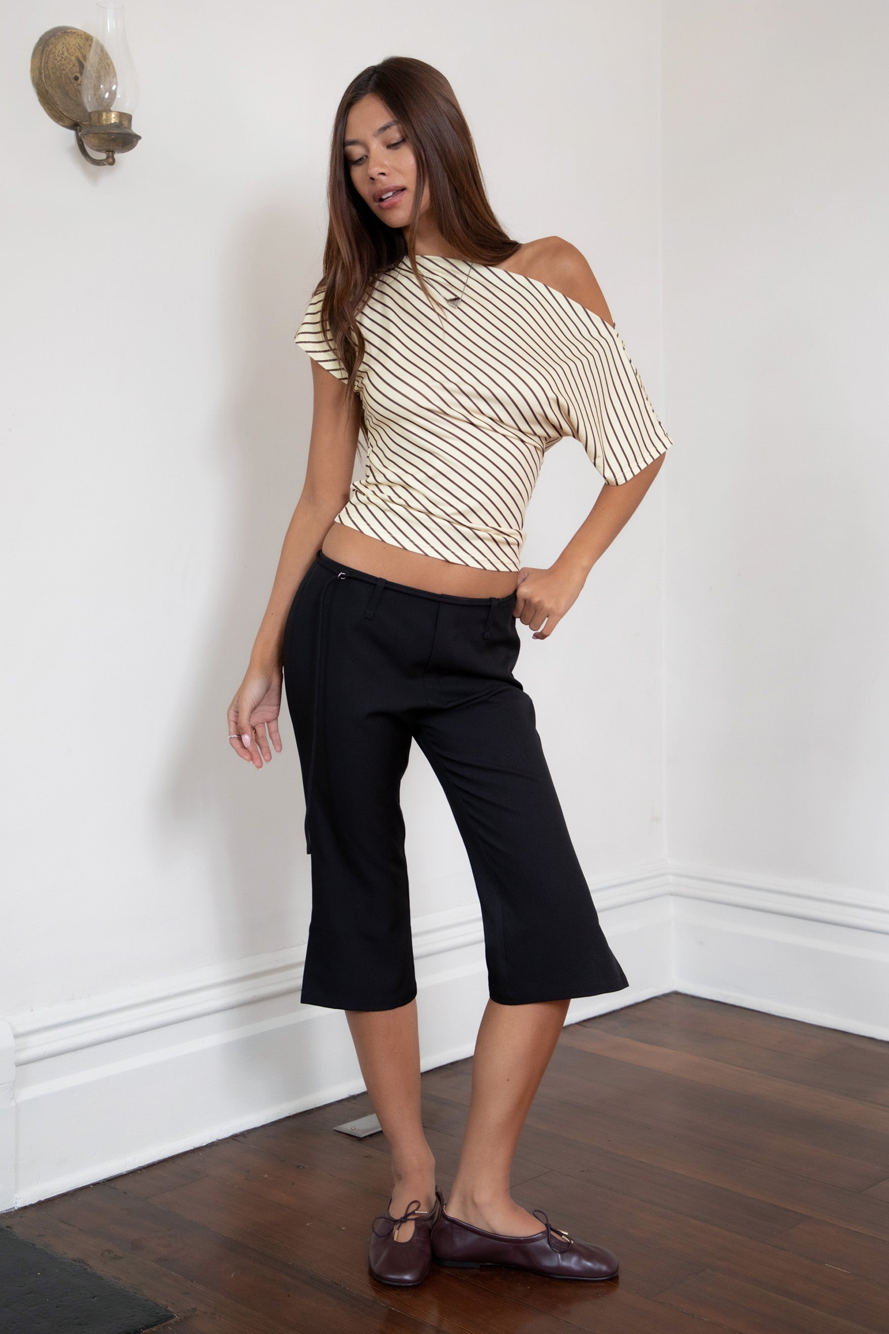 Woman wearing TIC TOC PH32127 COLETTE slit cropped dress pants featuring a sleek tailored capri silhouette, mid rise waistband with belt loops and adjustable tie detail, subtle side slit hem, and smooth stretch dobby fabric for a polished minimal day-to-night look.