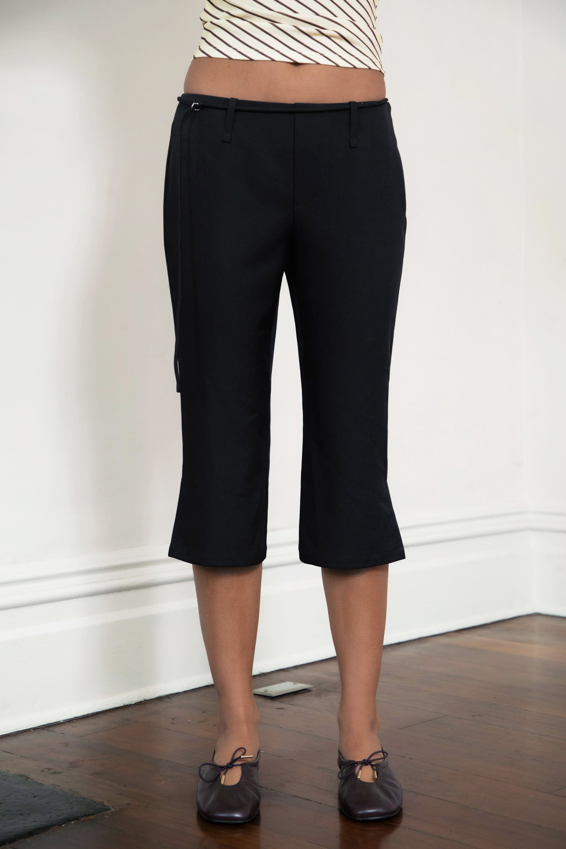 Woman wearing TIC TOC PH32127 COLETTE slit cropped dress pants featuring a sleek tailored capri silhouette, mid rise waistband with belt loops and adjustable tie detail, subtle side slit hem, and smooth stretch dobby fabric for a polished minimal day-to-night look.