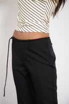 Woman wearing TIC TOC PH32127 COLETTE slit cropped dress pants featuring a sleek tailored capri silhouette, mid rise waistband with belt loops and adjustable tie detail, subtle side slit hem, and smooth stretch dobby fabric for a polished minimal day-to-night look.