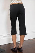 Woman wearing TIC TOC PH32127 COLETTE slit cropped dress pants featuring a sleek tailored capri silhouette, mid rise waistband with belt loops and adjustable tie detail, subtle side slit hem, and smooth stretch dobby fabric for a polished minimal day-to-night look.