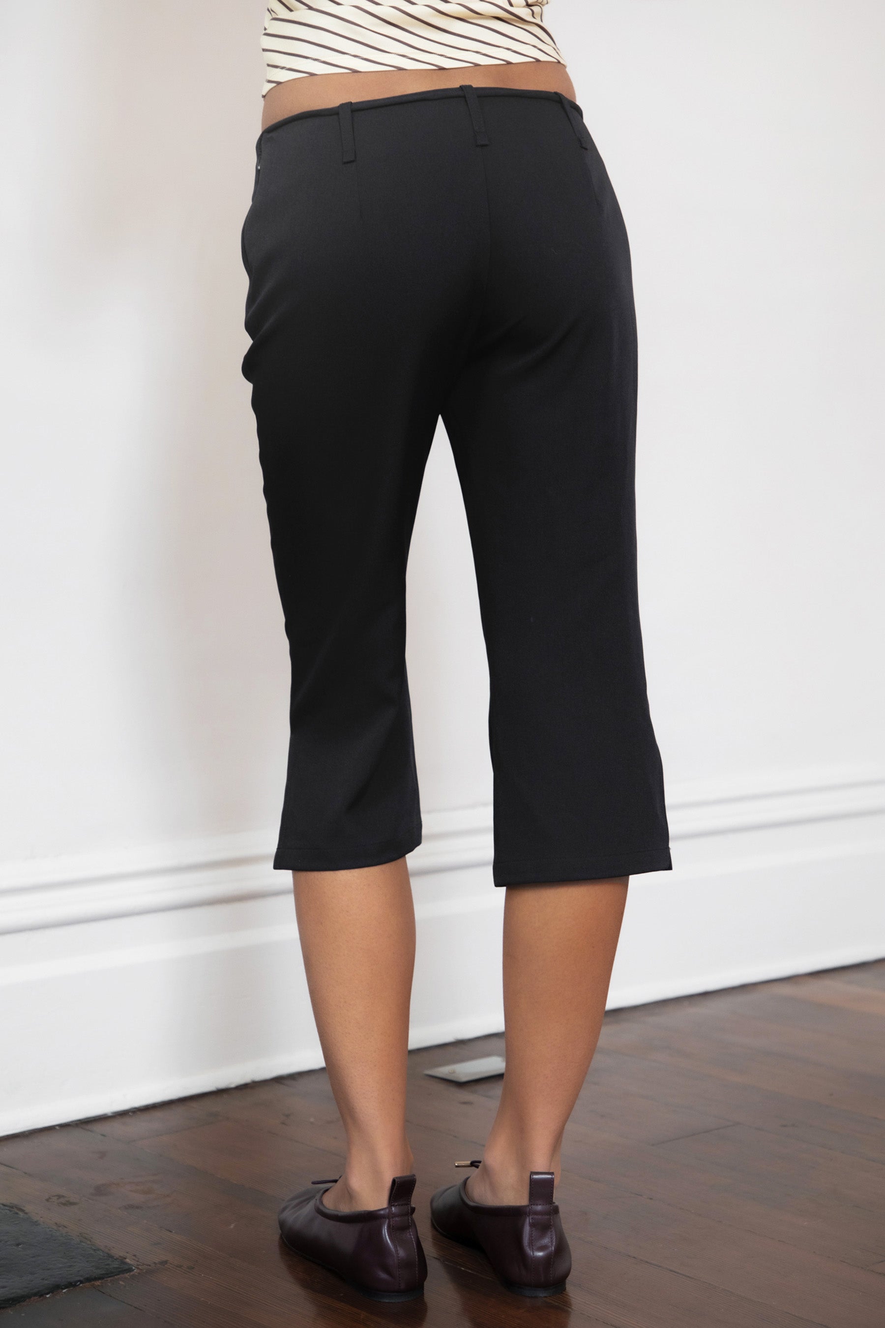 Woman wearing TIC TOC PH32127 COLETTE slit cropped dress pants featuring a sleek tailored capri silhouette, mid rise waistband with belt loops and adjustable tie detail, subtle side slit hem, and smooth stretch dobby fabric for a polished minimal day-to-night look.