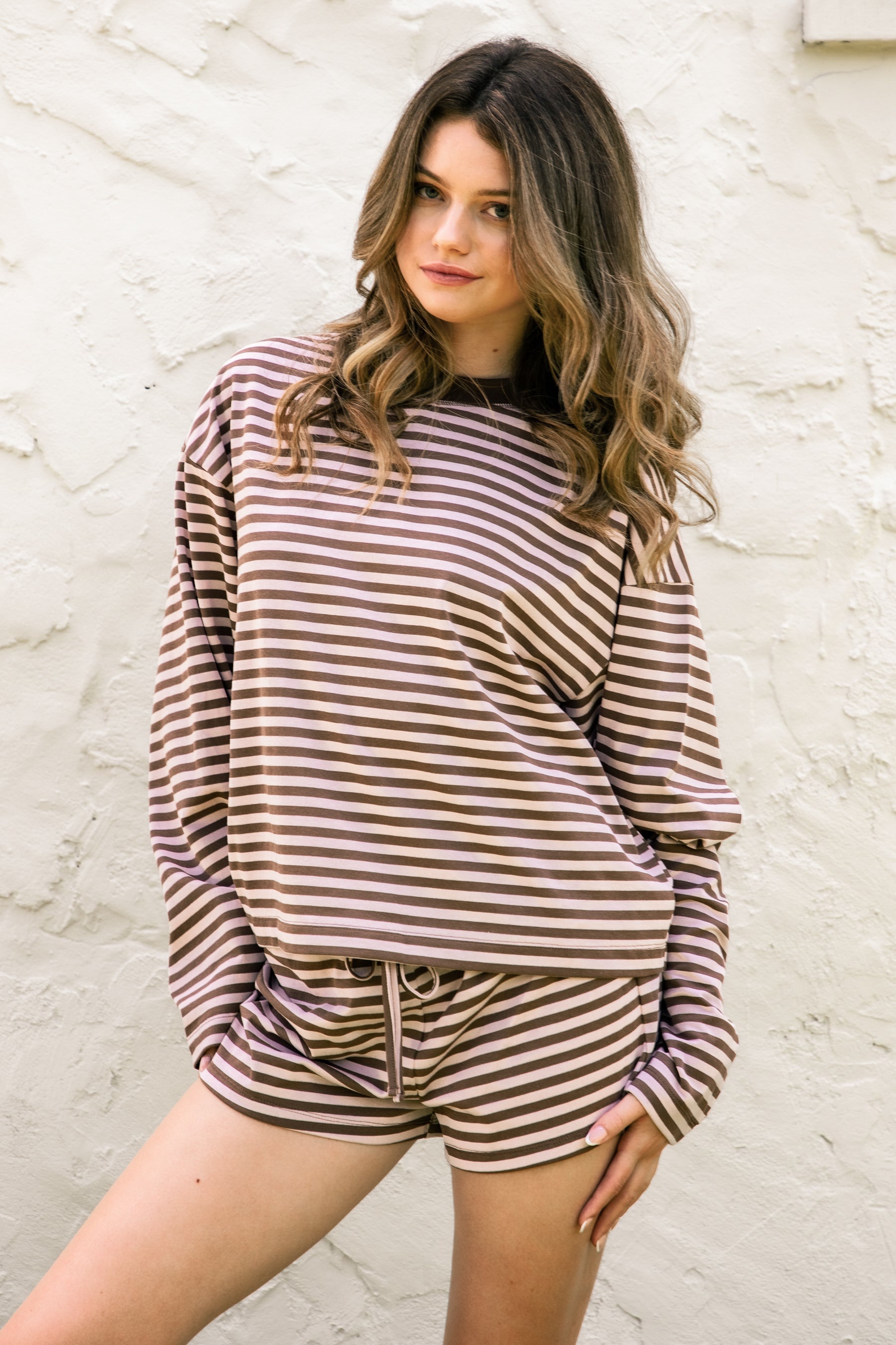 Woman wearing MARLOWE stripe mid waist drawstring stretch shorts featuring an allover stripe pattern, adjustable drawstring waistband, micro shorts length, relaxed easy fit silhouette, and soft stretch jersey fabric for cozy casual lounge styling.