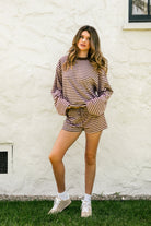 Woman wearing MARLOWE stripe mid waist drawstring stretch shorts featuring an allover stripe pattern, adjustable drawstring waistband, micro shorts length, relaxed easy fit silhouette, and soft stretch jersey fabric for cozy casual lounge styling.