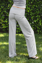 Woman wearing SAYLOR stripe stretch fold over wide leg pants featuring a fold over waistband, mid rise fit, wide leg relaxed silhouette, stripe jersey fabric, and lightweight stretch construction for soft comfortable lounge and casual styling.