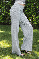 Woman wearing SAYLOR stripe stretch fold over wide leg pants featuring a fold over waistband, mid rise fit, wide leg relaxed silhouette, stripe jersey fabric, and lightweight stretch construction for soft comfortable lounge and casual styling.
