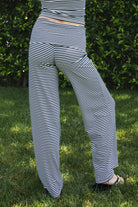 Woman wearing SAYLOR stripe stretch fold over wide leg pants featuring a fold over waistband, mid rise fit, wide leg relaxed silhouette, stripe jersey fabric, and lightweight stretch construction for soft comfortable lounge and casual styling.