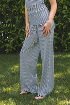 Woman wearing SAYLOR stripe stretch fold over wide leg pants featuring a fold over waistband, mid rise fit, wide leg relaxed silhouette, stripe jersey fabric, and lightweight stretch construction for soft comfortable lounge and casual styling.