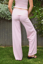 Woman wearing SAYLOR stripe stretch fold over wide leg pants featuring a fold over waistband, mid rise fit, wide leg relaxed silhouette, stripe jersey fabric, and lightweight stretch construction for soft comfortable lounge and casual styling.