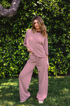 Woman wearing MARLOWE stretch mid waist stripe wide leg pants featuring an allover stripe pattern, adjustable drawstring waist, relaxed wide leg silhouette, full length fit, and soft stretch jersey fabric for cozy casual lounge styling.