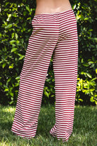 Woman wearing MARLOWE stretch mid waist stripe wide leg pants featuring an allover stripe pattern, adjustable drawstring waist, relaxed wide leg silhouette, full length fit, and soft stretch jersey fabric for cozy casual lounge styling.