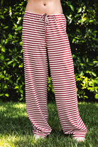 Woman wearing MARLOWE stretch mid waist stripe wide leg pants featuring an allover stripe pattern, adjustable drawstring waist, relaxed wide leg silhouette, full length fit, and soft stretch jersey fabric for cozy casual lounge styling.