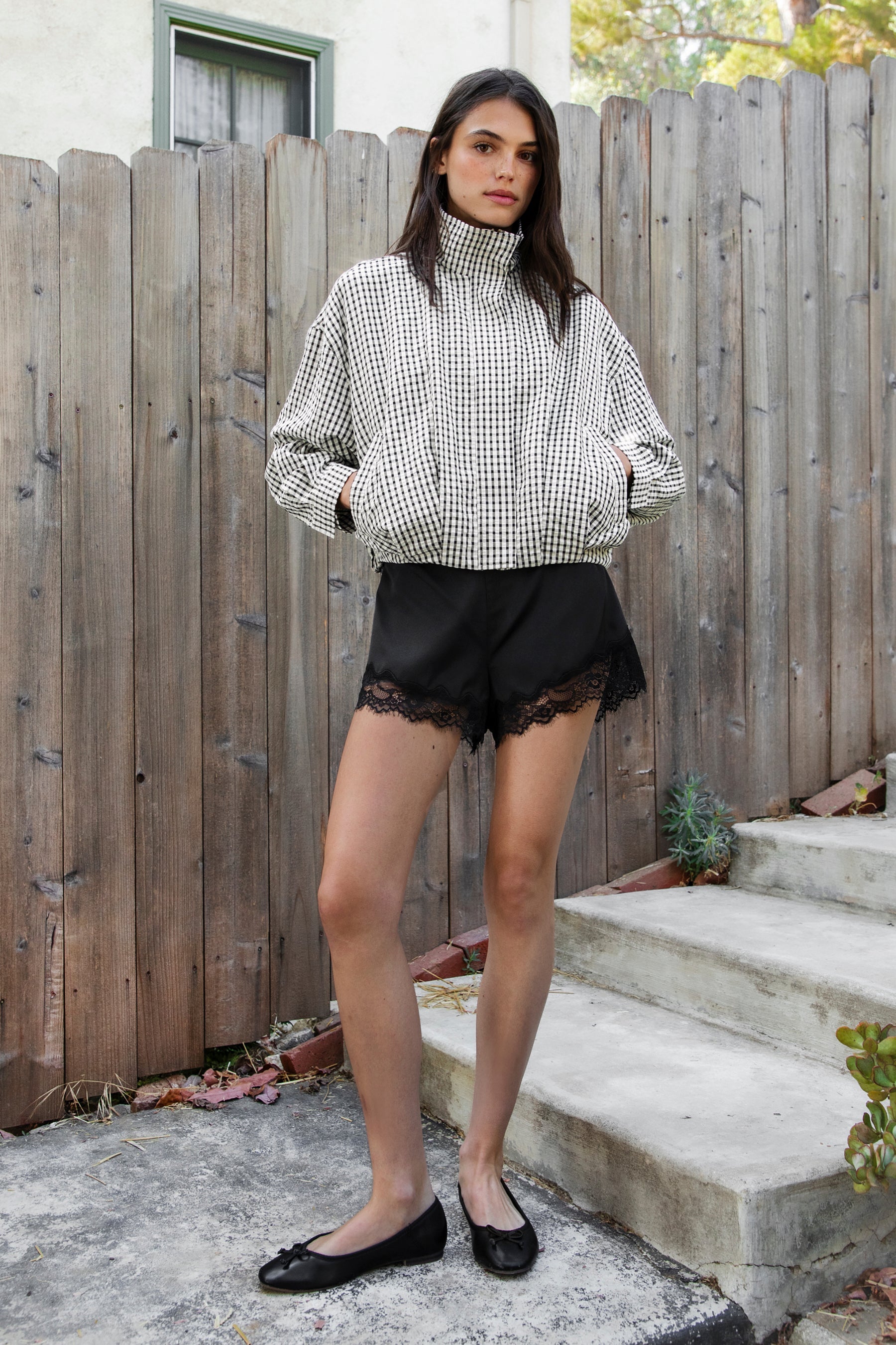 Woman wearing LUNETTE scalloped eyelash lace trim satin shorts featuring soft stretch satin fabric, high rise waist, clean tailored finish, delicate scalloped eyelash lace trim along the hem, hidden back zipper closure, and fully lined interior for added comfort and coverage.