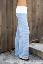 Woman wearing BRISA French terry stripe foldover waist wide leg pants featuring soft stretch French terry fabric, contrast foldover waistband, flattering low rise look, relaxed wide leg silhouette, classic stripe pattern, and pull on design for easy lounge and travel styling.