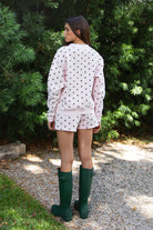 Woman wearing PIPPA polka dot plush fleece shorts featuring soft cotton blend fleece fabric, playful polka dot print, comfortable elastic waistband, easy pull on design, relaxed fit through the hips and legs, functional side pockets, short length, and clean finished hems designed to pair with the matching PIPPA sweatshirt.