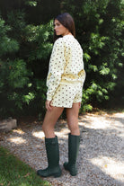 Woman wearing PIPPA polka dot plush fleece shorts featuring soft cotton blend fleece fabric, playful polka dot print, comfortable elastic waistband, easy pull on design, relaxed fit through the hips and legs, functional side pockets, short length, and clean finished hems designed to pair with the matching PIPPA sweatshirt.