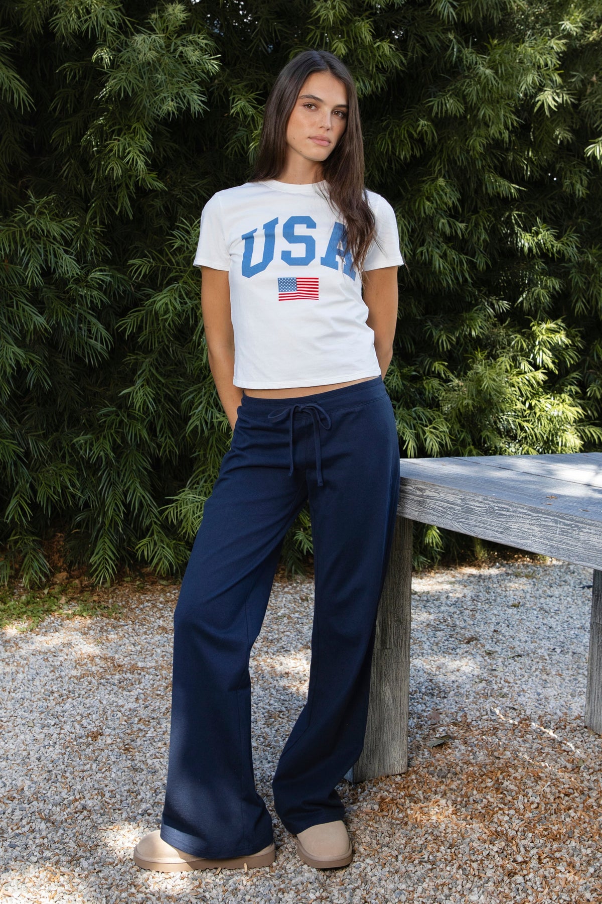 Woman wearing NAVYN waist band cotton wide leg pants featuring soft 100 percent cotton fabric, low rise waistline, relaxed fit, elastic waistband with adjustable drawstring tie, relaxed silhouette through the hips and thighs, wide leg design, full length cut, and straight hem for easy everyday styling.