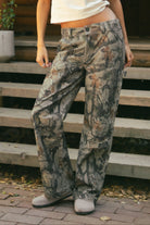 WILDWOOD Low Rise Camo Wood Carpenter Pants 
5 Pocket Denim Styling 
Hammer Loop At Side 
Zipper Button Fly Closure 
Belt Loop Waist
Wide Leg Design 
Contemporary Forest Camo Wood in Green
Quality Camo Twill Low Stretch Fabric
Back To School Western Rodeo Outfit Fashion Inspo