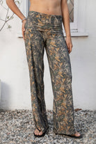 Woman wearing BAYOU dark woodland camo stretch foldover wide leg leggings featuring soft brushed stretch jersey fabric, allover woodland camo print, adjustable foldover waistband, relaxed wide leg silhouette, and four way stretch fabric designed for everyday comfort and easy movement.