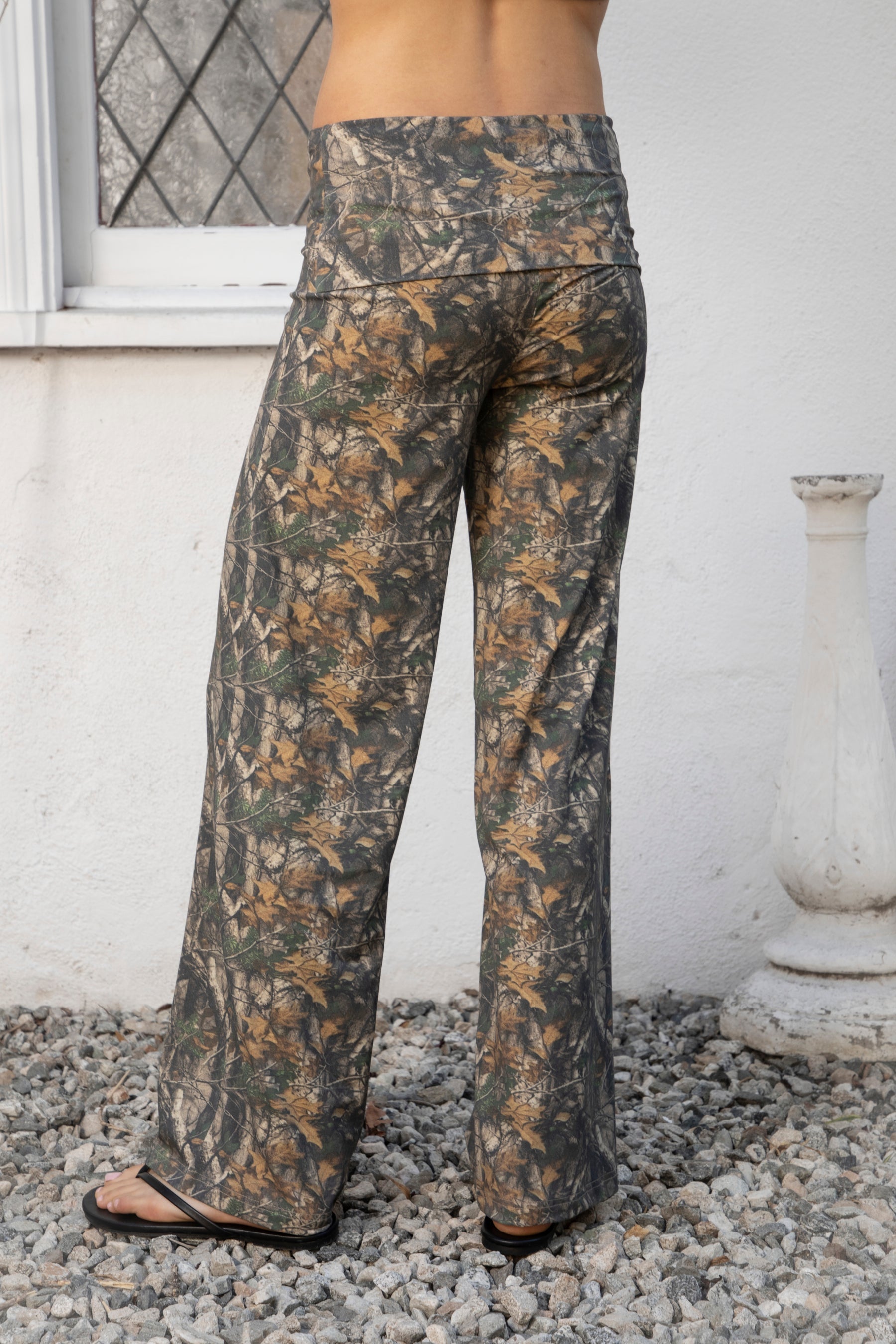 Woman wearing BAYOU dark woodland camo stretch foldover wide leg leggings featuring soft brushed stretch jersey fabric, allover woodland camo print, adjustable foldover waistband, relaxed wide leg silhouette, and four way stretch fabric designed for everyday comfort and easy movement.