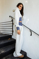 Woman wearing COSETTE polka dot waist wide leg sweatpants featuring soft fleece fabric, relaxed wide leg silhouette, contrast navy ribbed waistband with allover white polka dot pattern, high rise statement fit, soft heather grey body, full length design, functional side pockets, and matching set styling.