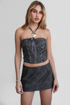 Woman wearing TIC TOC SC30492 RILEY PU vegan leather mini skirt featuring a sleek mini skort silhouette with built-in under shorts, hidden side zipper closure, and a smooth faux leather finish, styled with a matching top for an elevated going-out look.