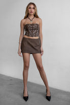 Woman wearing TIC TOC SC30492 RILEY PU vegan leather mini skirt featuring a sleek mini skort silhouette with built-in under shorts, hidden side zipper closure, and a smooth faux leather finish, styled with a matching top for an elevated going-out look.