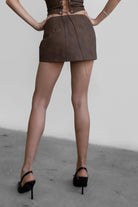 Woman wearing TIC TOC SC30492 RILEY PU vegan leather mini skirt featuring a sleek mini skort silhouette with built-in under shorts, hidden side zipper closure, and a smooth faux leather finish, styled with a matching top for an elevated going-out look.