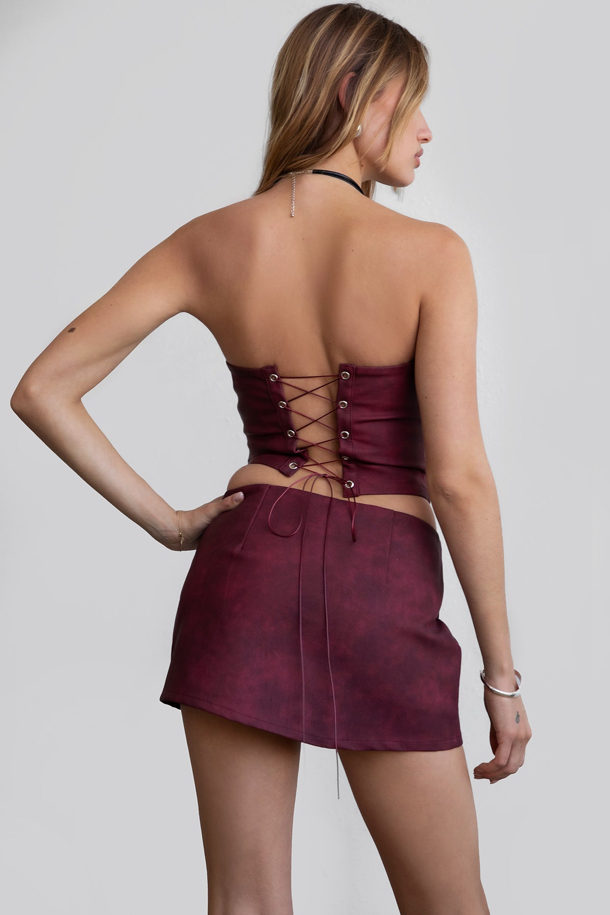 Woman wearing TIC TOC SC30492 RILEY PU vegan leather mini skirt featuring a sleek mini skort silhouette with built-in under shorts, hidden side zipper closure, and a smooth faux leather finish, styled with a matching top for an elevated going-out look.