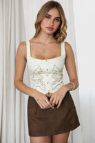 TIC TOC JESSIE Embroidered Suede Corset in Cream with square neckline, faux button front, and lace-up back.