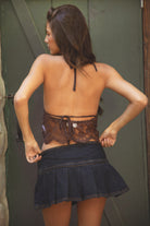 Woman wearing brown TA30997 LEYLI featuring a plunging V-neckline and scalloped lace hem, paired with a blue denim skirt