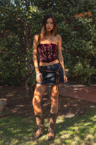 Woman wearing TIC TOC TA31782 BECKEE faux fur strapless western inspired embroidery corset top featuring a straight strapless neckline, structured cropped corset fit, soft faux fur texture, western embroidery detail, and adjustable lace-up back closure, styled for a festival-ready western concert look.