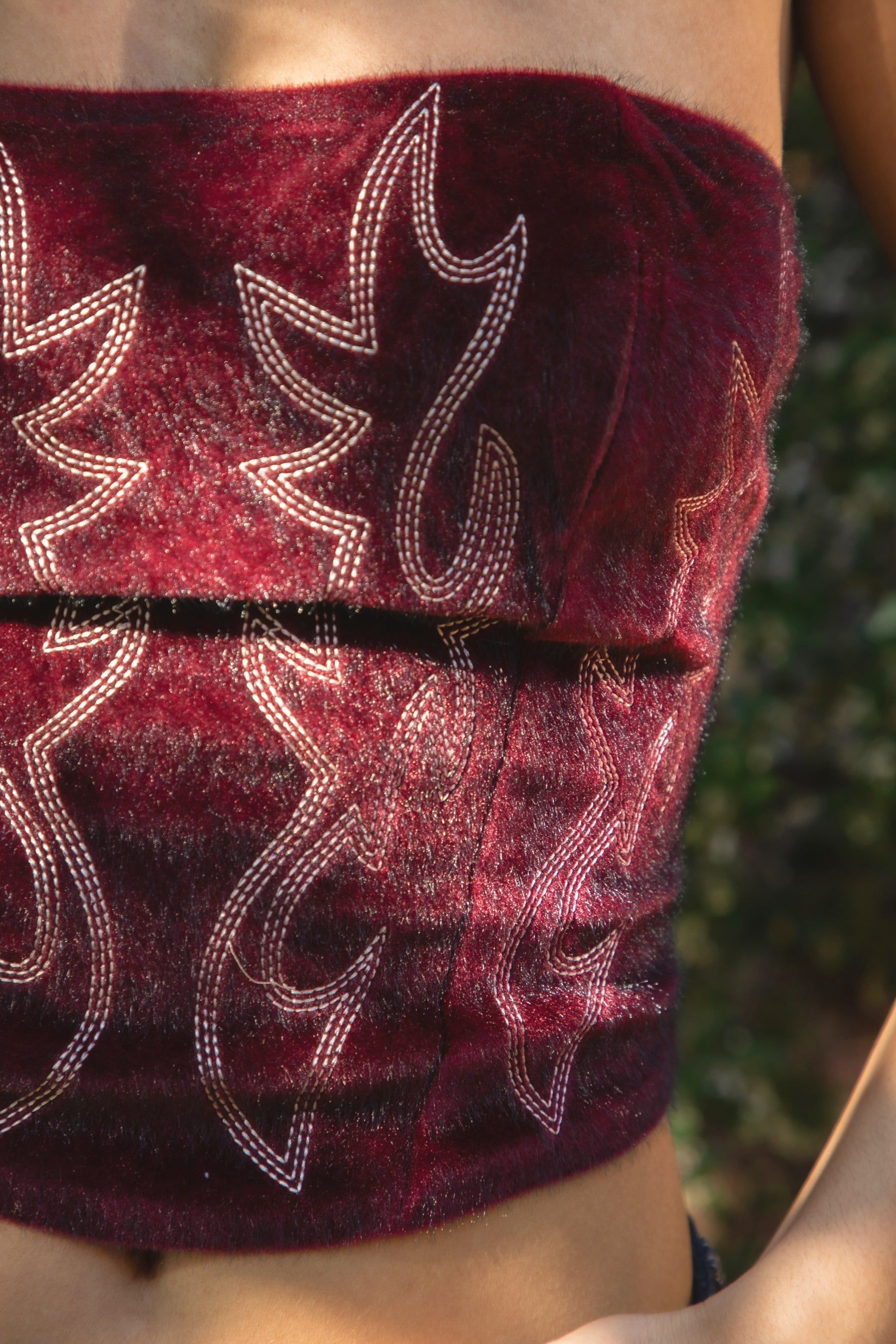 Woman wearing TIC TOC TA31782 BECKEE faux fur strapless western inspired embroidery corset top featuring a straight strapless neckline, structured cropped corset fit, soft faux fur texture, western embroidery detail, and adjustable lace-up back closure, styled for a festival-ready western concert look.