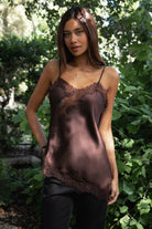 Woman wearing TIC TOC TA31968 SELINNE satin lace contrast V-neck cami top featuring smooth satin fabric, a flattering V neckline with scalloped lace trim, thin adjustable shoulder straps, and an asymmetrical lace-trim hem for a soft feminine date-night look.