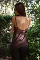 Woman wearing TIC TOC TA31968 SELINNE satin lace contrast V-neck cami top featuring smooth satin fabric, a flattering V neckline with scalloped lace trim, thin adjustable shoulder straps, and an asymmetrical lace-trim hem for a soft feminine date-night look.