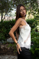 Woman wearing TIC TOC TA31968 SELINNE satin lace contrast V-neck cami top featuring smooth satin fabric, a flattering V neckline with scalloped lace trim, thin adjustable shoulder straps, and an asymmetrical lace-trim hem for a soft feminine date-night look.